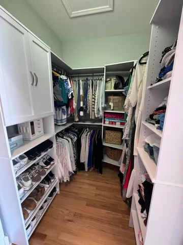 a view of walk in closet with clothes and shoes