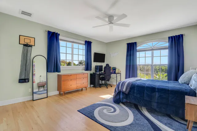 a bedroom with a bed and wooden floor