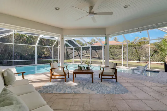 a living room with furniture a flat screen tv and a large window