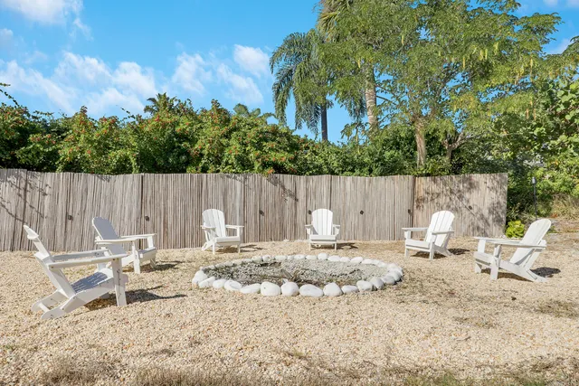 an aerial view of a house with swimming pool and large trees