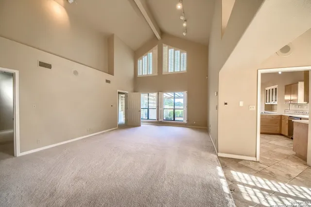 a view of a big room with windows and chandelier