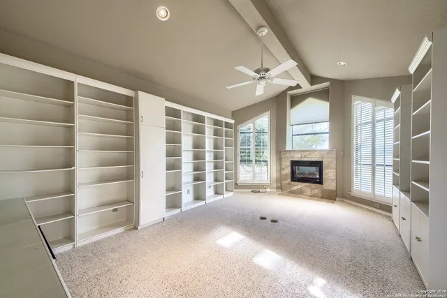 a view of an empty room with a fireplace and a window