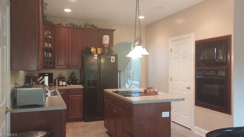 4910 Cade Road Climax, NC 27233 - Photo 5 of 13 Kitchen with cherry 42 inch cabinets, built in oven & microwave, cook top island, and hard surface counter top