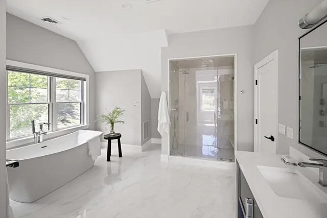 a spacious bathroom with a bathtub sink and mirror