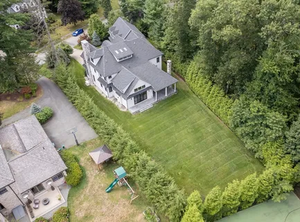 an aerial view of a house with a yard basket ball court and outdoor seating