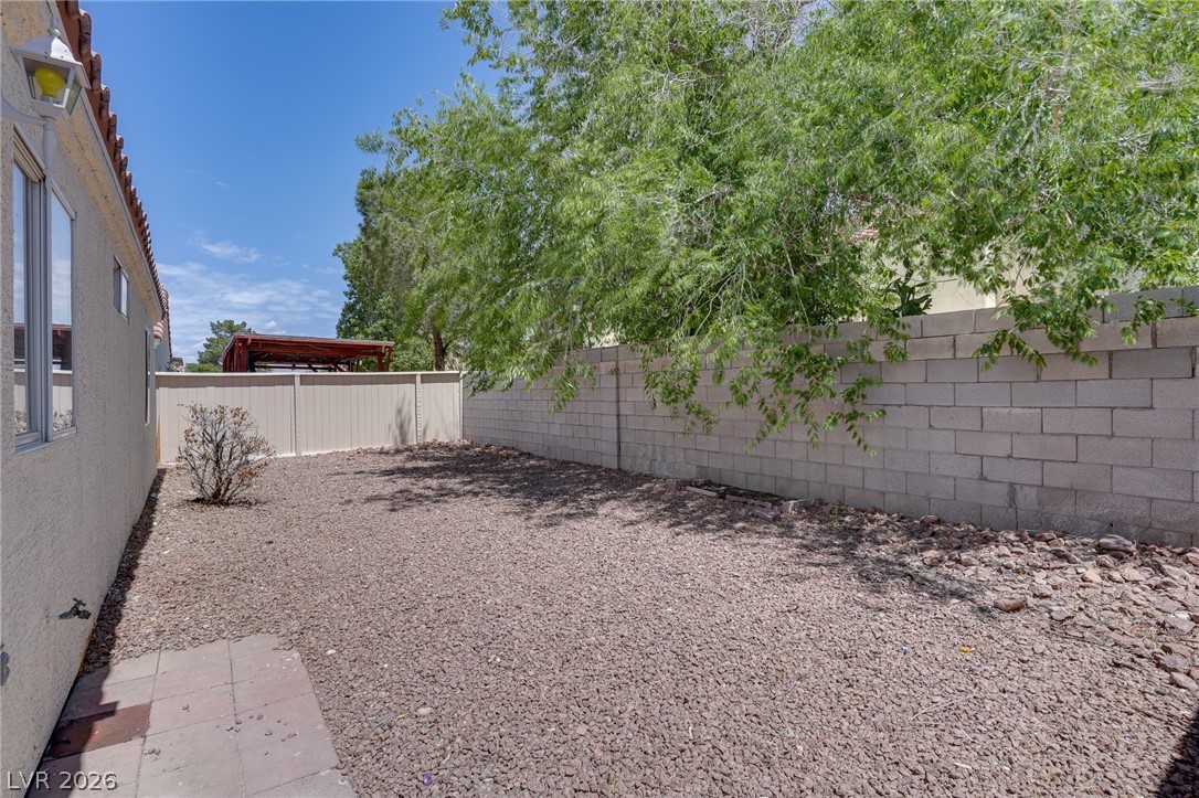 9660 Crystal Ridge Road Las Vegas, NV 89123 - Photo 4 of 13 A well-maintained side yard offers ample space with a sturdy block wall and shade trees.
