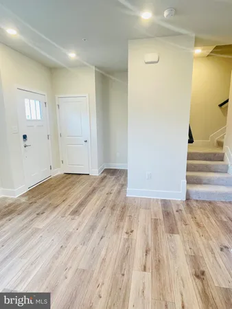 a view of a room with wooden floor and entryway