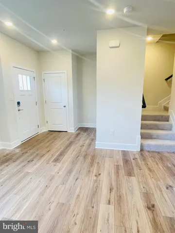 a view of a room with wooden floor and entryway