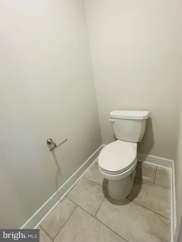 a white toilet sitting next to a shower