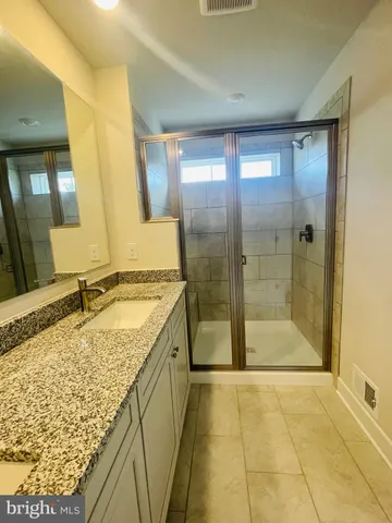a bathroom with a granite countertop sink and a mirror