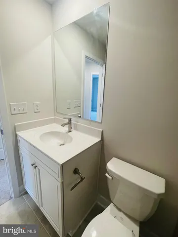 a bathroom with a toilet a sink and mirror