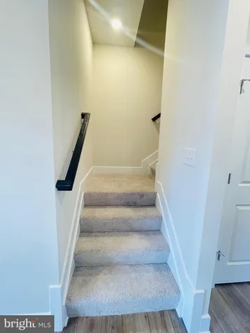 a view of staircase with white walls and white door