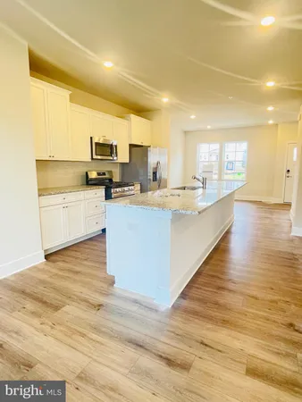 a kitchen with stainless steel appliances a sink and a wooden floors