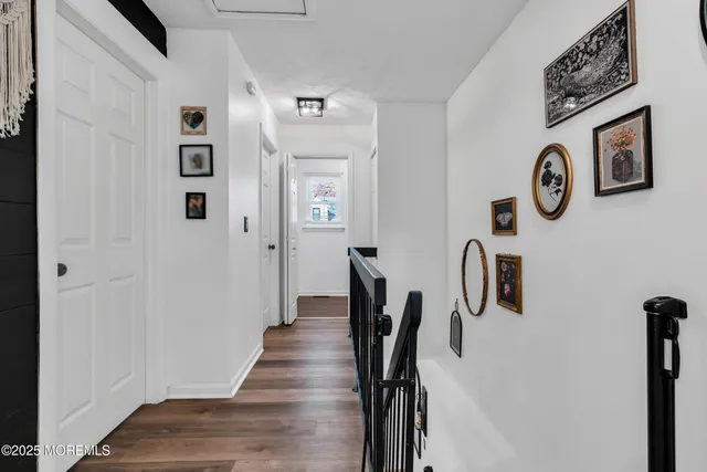 a view of a hallway with wooden floor and stairs