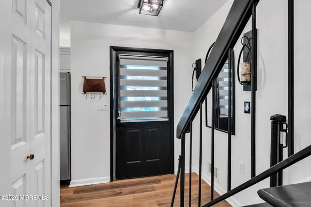 a view of an entryway with wooden floor and door