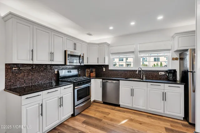 a kitchen with stainless steel appliances granite countertop a sink and cabinets