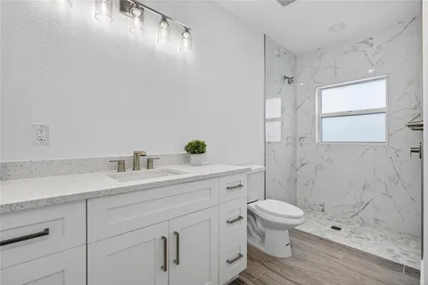 a bathroom with a sink a toilet and shower