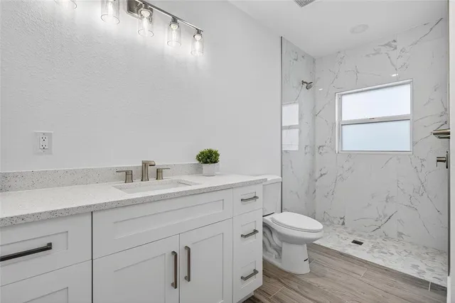 a bathroom with a sink a toilet and shower