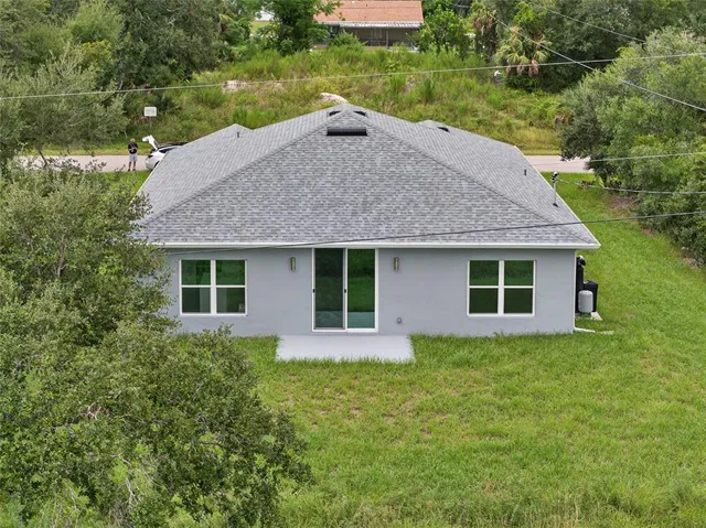 a front view of house with yard and trees in the background