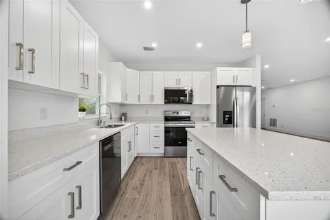 a kitchen with white cabinets and stainless steel appliances