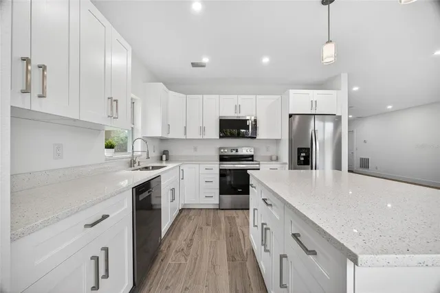 a kitchen with white cabinets and stainless steel appliances