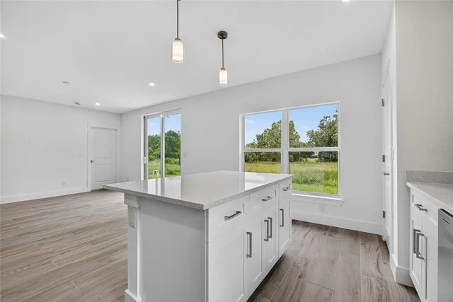 a view of a kitchen with wooden floor and a window