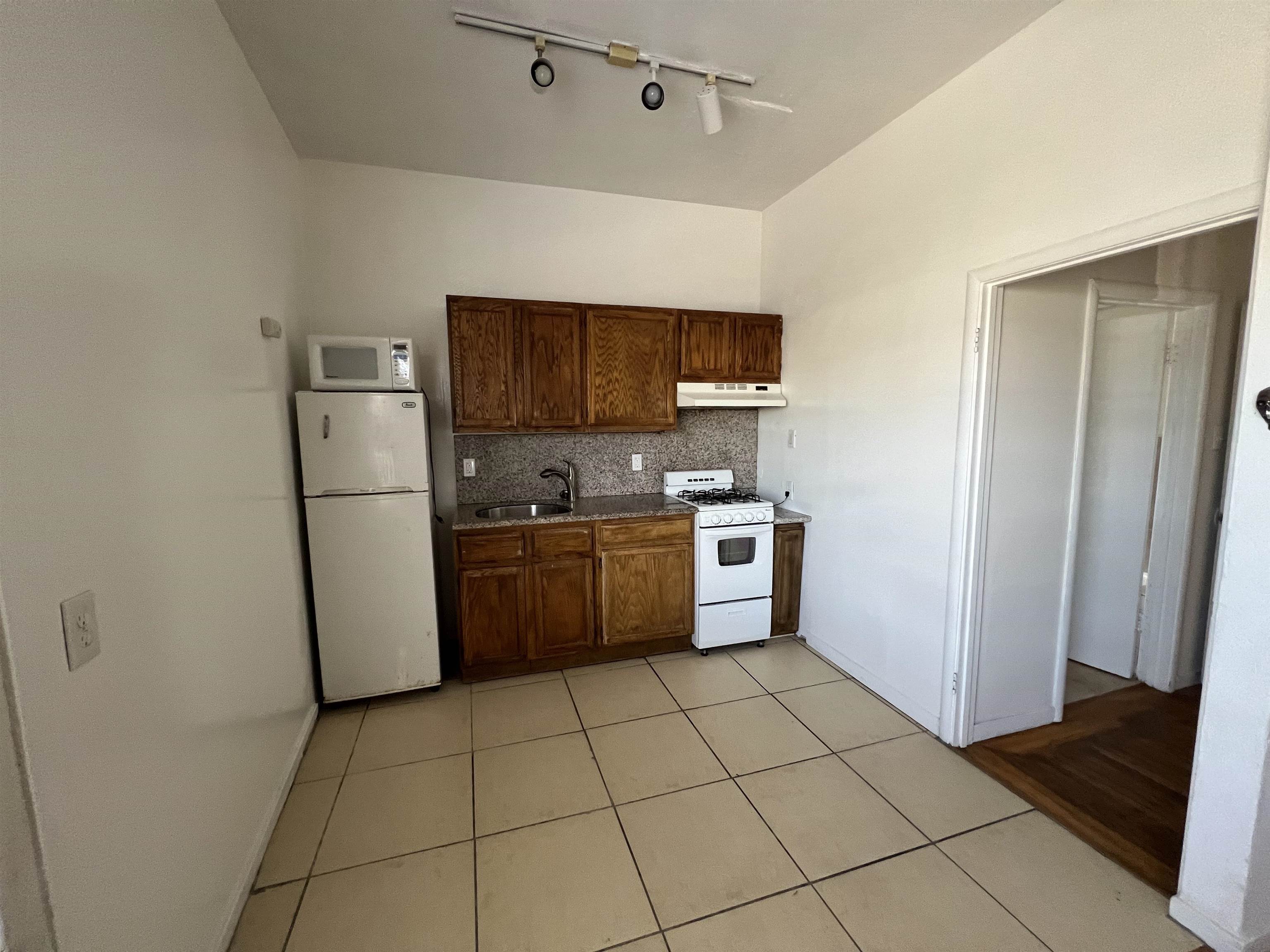 3244 Ellis Street, Unit B Berkeley, CA 94703 - Photo 3 of 4 a kitchen with a refrigerator a sink and a stove top oven