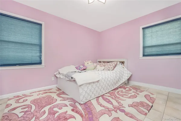 a bedroom with a bed mirror and a window