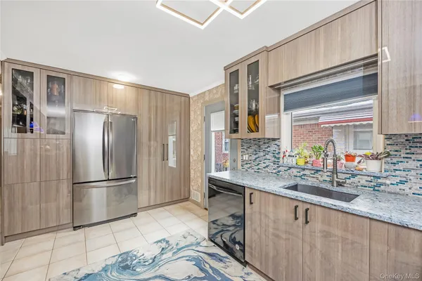 a kitchen with stainless steel appliances granite countertop a sink and a refrigerator