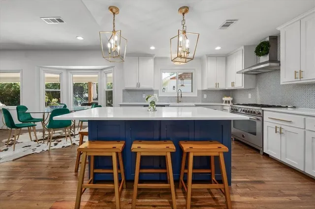 a large kitchen with cabinets a sink a center island and appliances