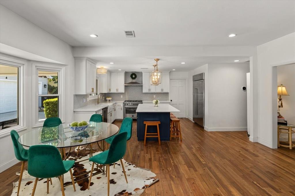 6305 Genoa Road Fort Worth, TX 76116 - Photo 3 of 33 a open dining room with kitchen island furniture a wooden floor and a kitchen view