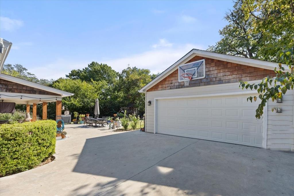 6305 Genoa Road Fort Worth, TX 76116 - Photo 32 of 33 a backyard of a house with a tree and wooden fence