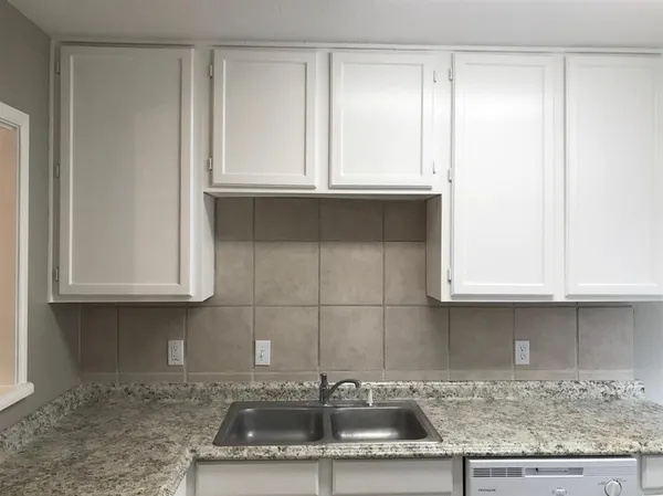 a kitchen with granite countertop a sink and cabinets