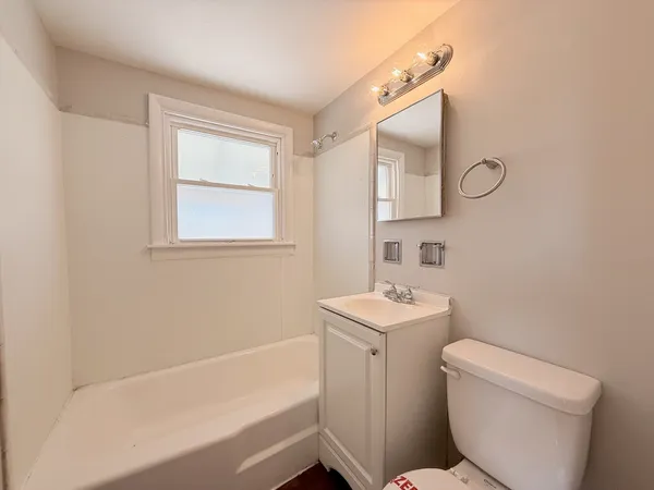 a bathroom with a sink toilet vanity and bathtub