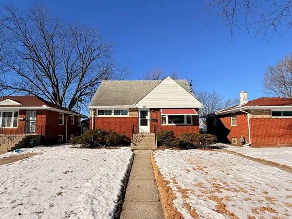a front view of a house with a yard covered in snow
