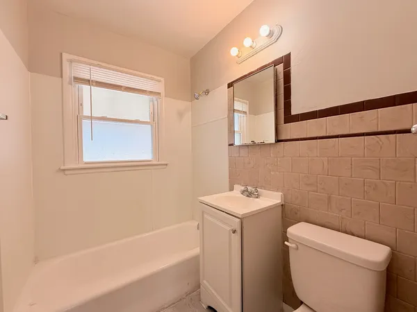 a bathroom with a toilet sink and mirror