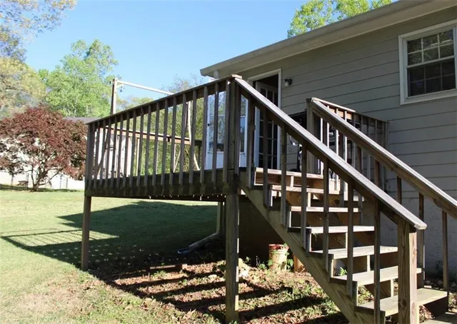 a view of a house with backyard and deck