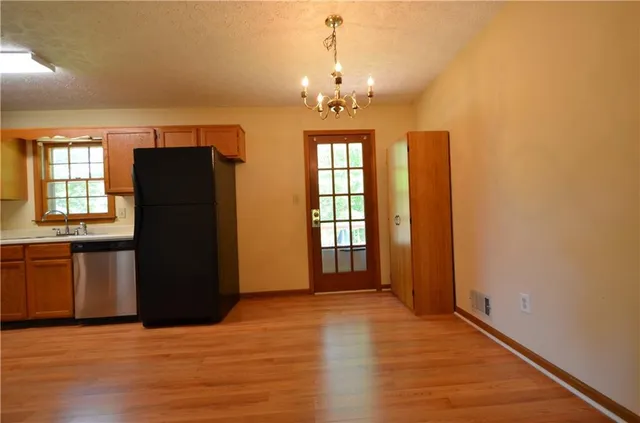 an empty room with kitchen and window