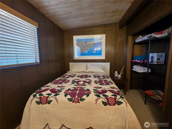 a bedroom with a bed and a painting on the wall