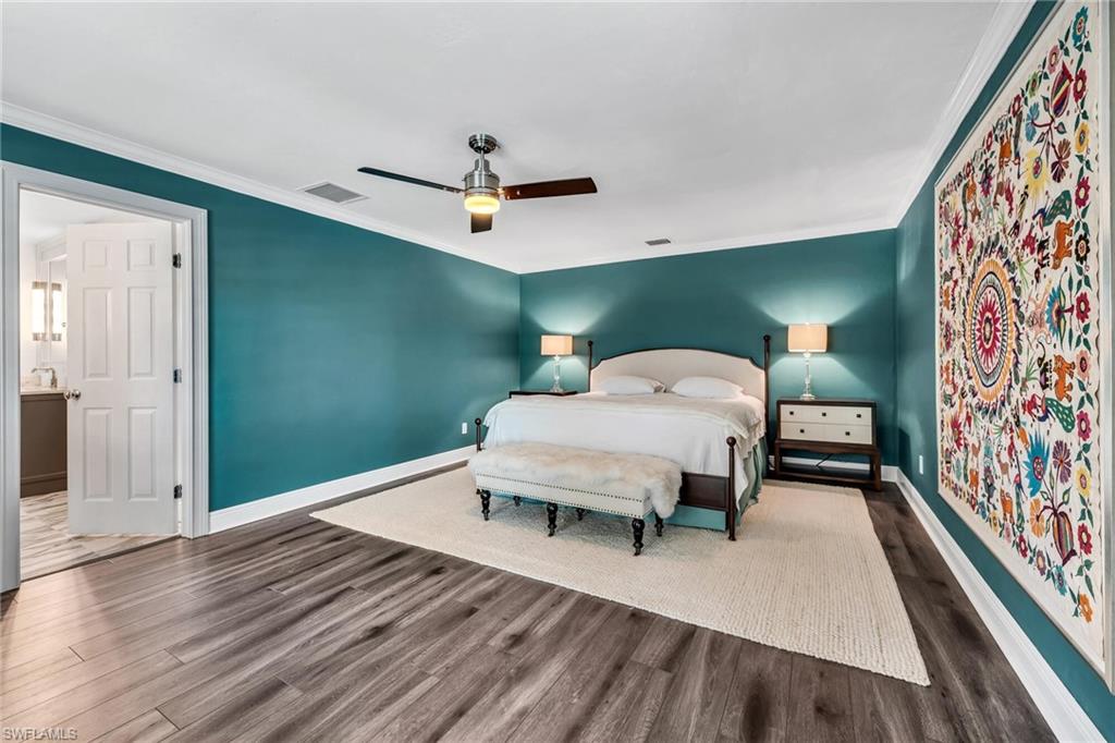 1966 Imperial Golf Course Boulevard Naples, FL 34110 - Photo 15 of 32 a bedroom with a bed and a chandelier