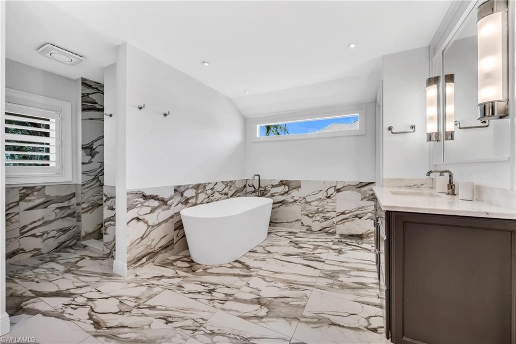 1966 Imperial Golf Course Boulevard Naples, FL 34110 - Photo 18 of 32 a bathroom with a bathtub and a sink