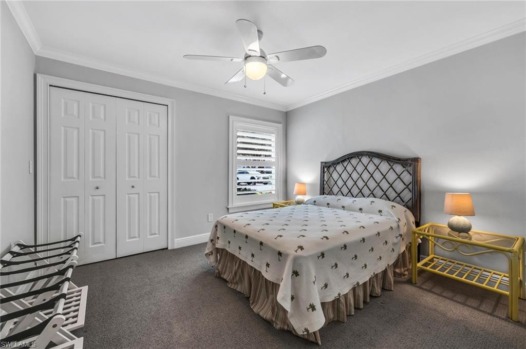 1966 Imperial Golf Course Boulevard Naples, FL 34110 - Photo 19 of 32 a bedroom with a bed and a chandelier