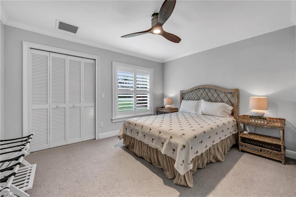 1966 Imperial Golf Course Boulevard Naples, FL 34110 - Photo 20 of 32 a bedroom with a bed and a chandelier
