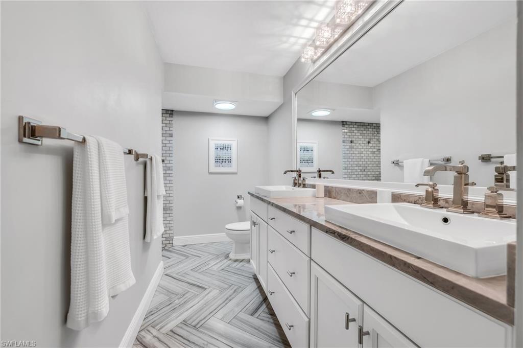 1966 Imperial Golf Course Boulevard Naples, FL 34110 - Photo 22 of 32 a spacious bathroom with a double vanity sink a mirror and a shower