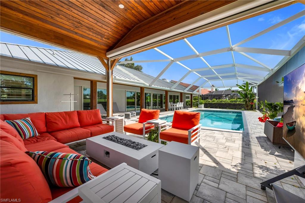 1966 Imperial Golf Course Boulevard Naples, FL 34110 - Photo 26 of 32 a outdoor space with patio couches and a table and chairs with garden view