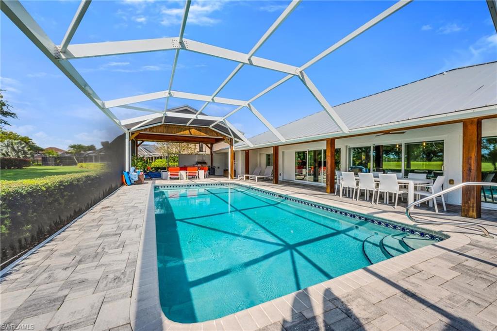 1966 Imperial Golf Course Boulevard Naples, FL 34110 - Photo 4 of 32 a view of a patio with a table and chairs under an umbrella