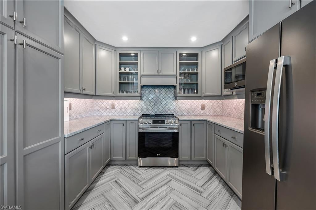 1966 Imperial Golf Course Boulevard Naples, FL 34110 - Photo 6 of 32 a kitchen with stainless steel appliances granite countertop a sink stove and refrigerator