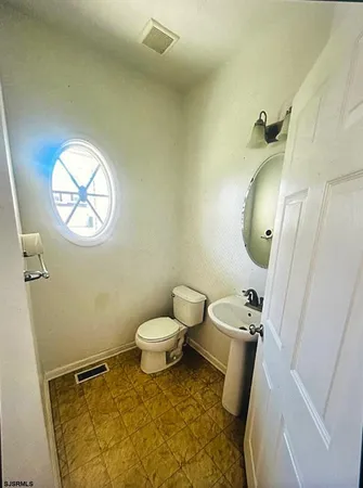 a bathroom with a toilet and a mirror
