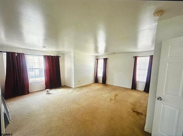 an empty room with windows and closet