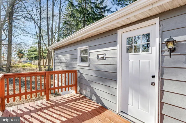 a backyard of a house with a large tree and wooden fence